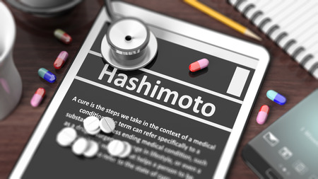 Tablet with "Hashimoto" on screen, stethoscope, pills and objects on wooden desktop.の写真素材