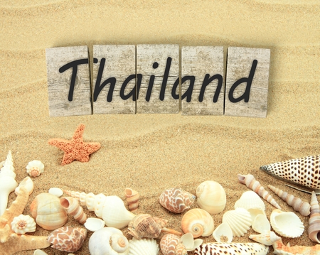 Thailand on wooden board pieces with sea shells and sandの写真素材