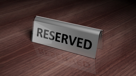 Silver glossy reservation sign on wooden surface with reflectionの写真素材
