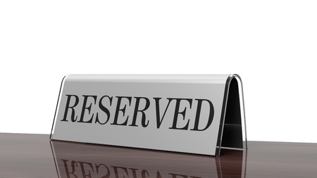 Glossy reservation sign on wooden surface, isolated on white background.の写真素材