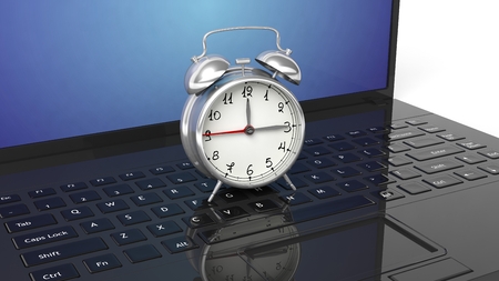 Red alarm clock on black laptop keyboard.