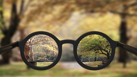 Closeup on eyeglasses with focused and blurred landscape view.の写真素材