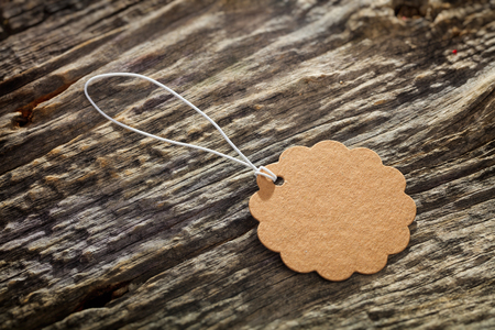 Close-up of carton flower shaped label with white rope on tree barkの写真素材
