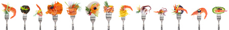 Variety of seafood appetizers on forks - white backgroundの写真素材