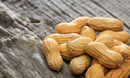 Unpeeled peanuts on an old wooden table, copy spaceの写真素材
