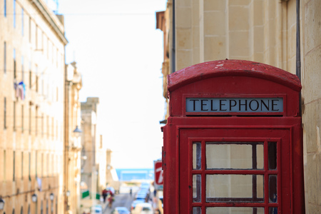 Traditional red British telephone booth. Blank, old, peeled phone box in Valletta, Malta. Space for...