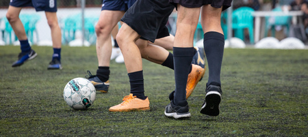 Football concept. Football soccer players playing in a football field on a sunny day, banner.の写真素材