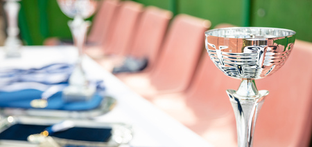 Champion awards concept. Silver trophy cup on a table with bokeh background.の写真素材
