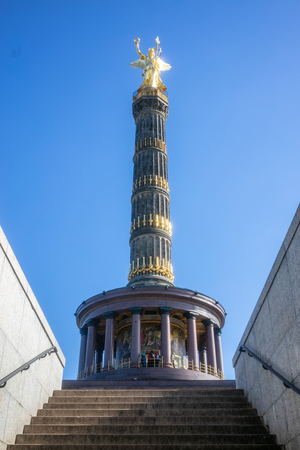 Berlin Victory Column. Golden statue of angel holding a gold laurel wreath, tries to touch the blue skyの写真素材