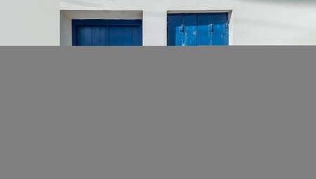 Window shutters on a wall. Facade of old stone building, closeup.の写真素材