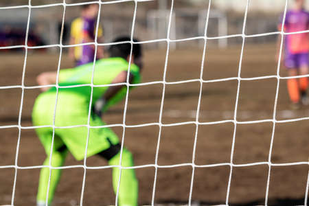 Football Soccer goalkeeper with color uniform, from behind view.