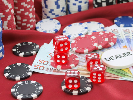 Red dice, poker chips, money and cards on red background.の写真素材