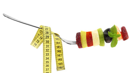 Healthy lifestyle, Fresh fruits slices and a measure tape isolated on white transparent backgroundの写真素材