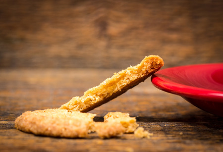 Biscuit and coffeecup plate on wooden tableの写真素材