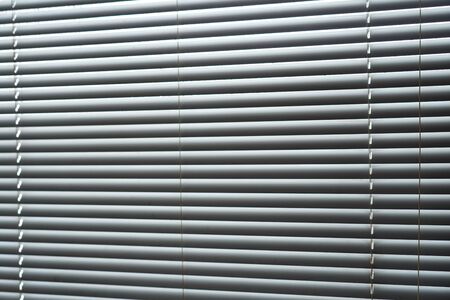 Blinds, texture blinds. Texture blinds office. White closed jalousie at day illumination. Blinds plastic texture background.の写真素材