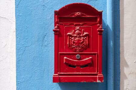 Red mail box. Red decorative mailbox in the village of Burano in Venetian Lagoon. Colourful post box in Burano, Italy.の写真素材