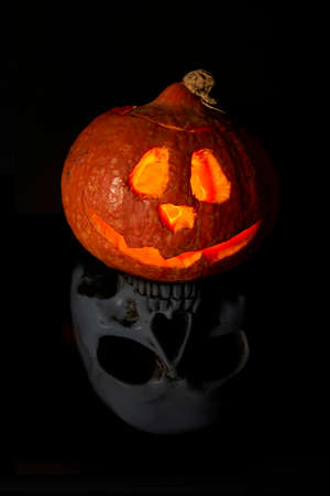 Halloween pumpkin head lantern on black background. Jack-o-lantern carved pumpkins for Halloween close up. Halloween pumpkin with eyes glowing inside at black background. idea for halloween 2020の写真素材