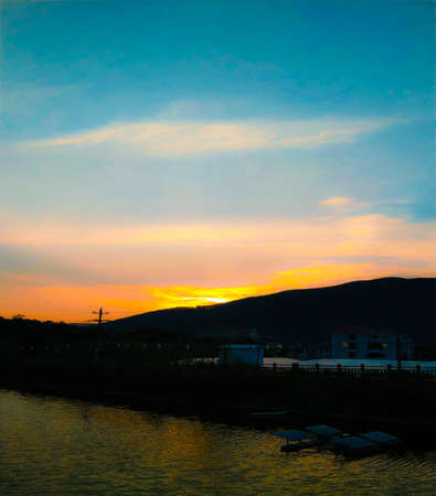 a cloudy sunset landscape with sunの写真素材