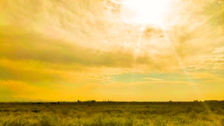 Beautiful cloudy sunset landscape with sunの写真素材