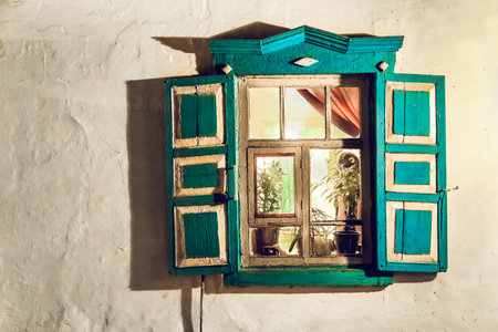 A window in Russia with a green frame and white trim. The window is open and has a reflection of a...