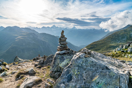 A rock with a stack on top of it. The sky is blue and clearの写真素材