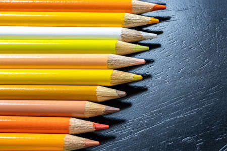 Colorful pencils on black background, closeup. Space for text