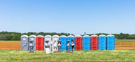 Row of colorful mobility lavatory and washbasin, hygiene facility for people at outdoor event. Public temporary restroom at a park, attendees using amenity during festival, convenience and sanitationの写真素材