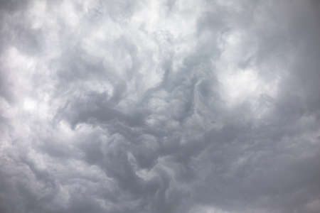 Light and dark grey storm clouds waves over the sky before heavy rain. Dramatic cumulonimbus, moody and aggressive cloudscape. Scene of dull overcast thunderstorm. Abstract cloudy nature background.の写真素材