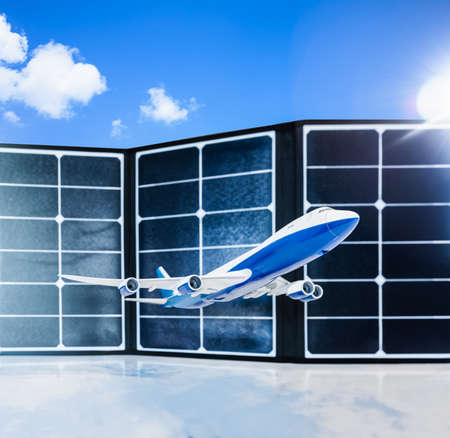 Model commercial airplane fly with solar cells panel and sunlight in clouds blue sky background, depth of field. Aviation industry business with eco friendly energy power concept. Innovative airplane.の写真素材