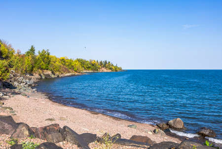 Sea horizon, calm ocean, tropical lake among bush natures. Deep blue water, sand beach and clear...