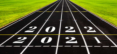 New year concept with black rubber running track with numbers, ideas of overcome year 2021 to coming year 2022. Start of racing, challenging and competition to goal and success conceptual.の写真素材
