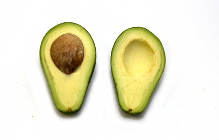 Two slices of fresh organic avocado isolated on a white background. One slice with core. Design...