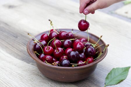 Fresh cherry on plate on wooden grey background. fresh ripe cherries. sweet cherries. Sweet cherries...