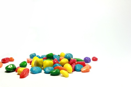 A number of brilliantly coloured pebbles against a white background .の写真素材