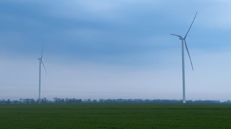 An image of windturbines in a field under a blue skyの写真素材