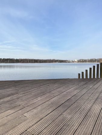 Wooden pier on a lake with blue sky in the background.の写真素材