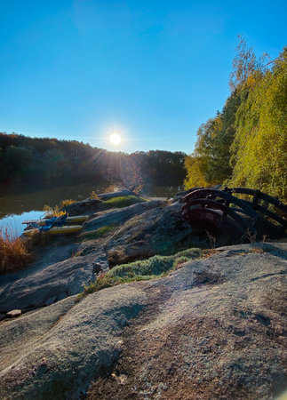 Beautiful autumn landscape with river, forest and blue sky with cloudsの写真素材