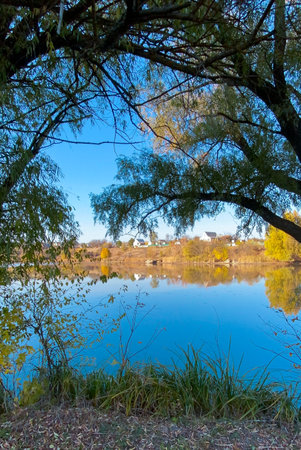 Autumn landscape with the image of the river, trees and blue skyの写真素材