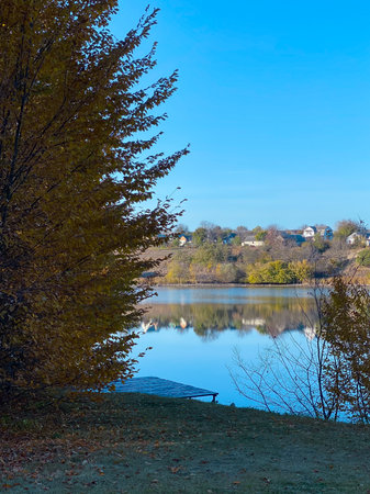 Autumn landscape with a lake and trees in the city park.の写真素材