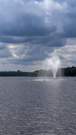Fountain on the lake in the summer with cloudy sky background.の写真素材