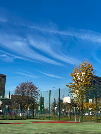 Basketball court and blue sky with white clouds in the background.の写真素材