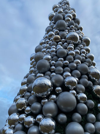 Christmas tree made of black and white balls on a background of blue cloudy skyの写真素材