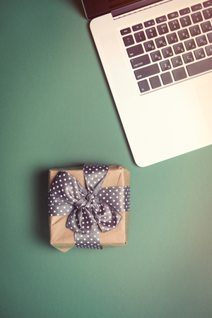 beautiful small gift and modern silver laptop on the wonderful blue backgroundの写真素材