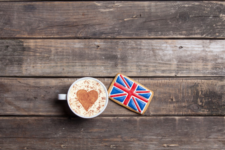 british flag shaped cookie and cup of coffee on the wonderful brown wooden backgroundの写真素材