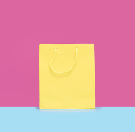 cool yellow shopping bag in front of the wonderful pink backgroundの写真素材