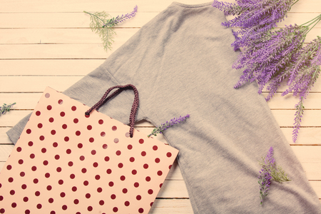 grey shirt, shopping bag and bunch of lavender on the white wooden backgroundの写真素材