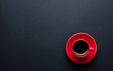 photo of red cup of fresh coffee on the wonderful black studio backgroundの写真素材