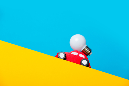 photo of car shaped toy and bulb on the wonderful blue studio backgroundの写真素材