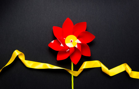 Little pinwheel toy with ribbon on black backgroundの写真素材