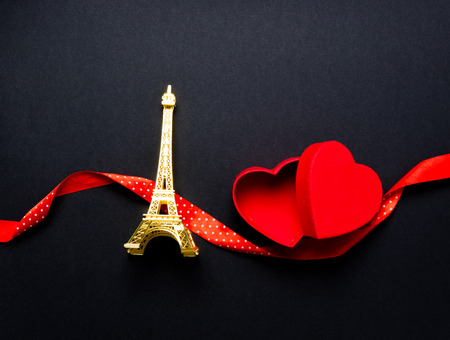 Eiffel tower toy and heart shape box with ribbon on black backgroundの写真素材
